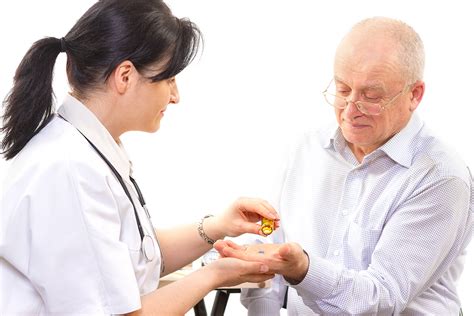 Senior Man Receiving Medications From Female Healthcare Professional