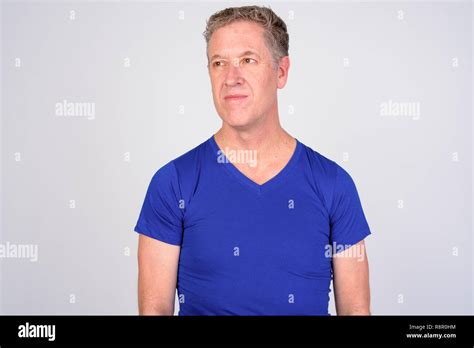 Mature Man Thinking While Looking Away Against White Background Stock