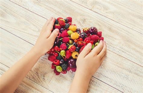 Premium Photo Cropped Hands Of Woman Holding Strawberries On Table