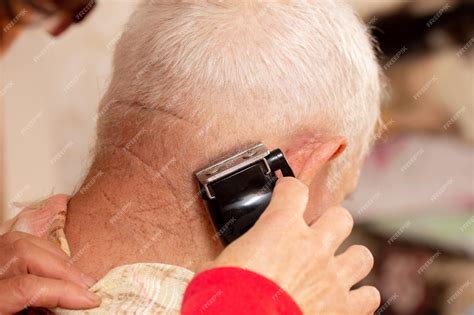 Premium Photo Haircut Of An Elderly Man At Home A Woman Cuts An Elderly Mans Hair With A Trimmer