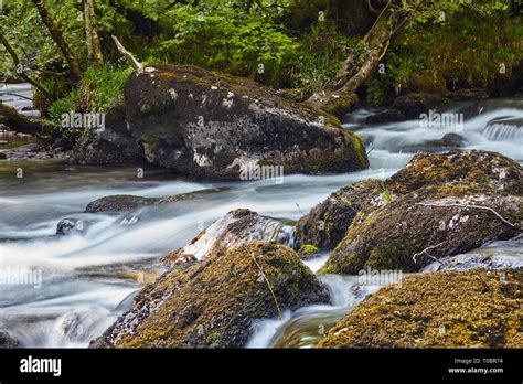 An Upland River Flowing Over And Around Boulders As It Flows Downhill