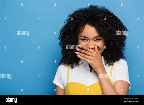 Excited African American Woman Covering Mouth With Hand While Laughing