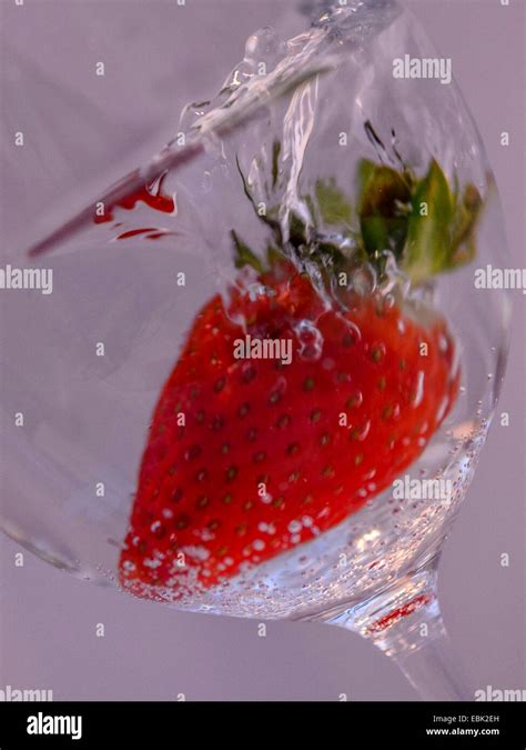 Studio Macro High Speed Image Of A Vibrant Red Strawberry In A Glass