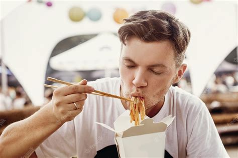 Premium Photo Stylish Hipster Man Eating Delicious Wok Noodles With