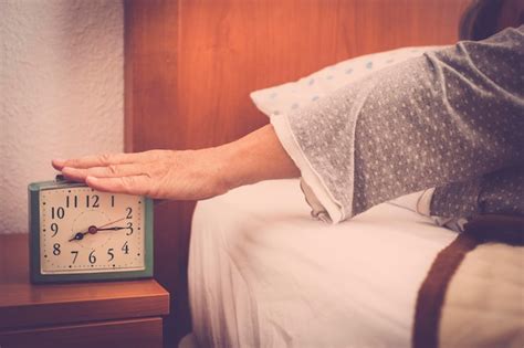 Premium Photo Cropped Hand Turning Off Alarm Clock In Bedroom At Home