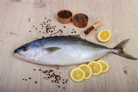 Fresh Fish With Lemon Parsley And Spice On Wooden Cutting Board