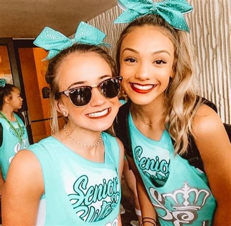 Two Girls In Matching Shirts And Sunglasses Posing For The Camera