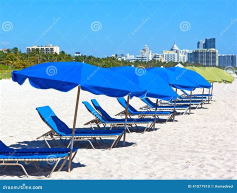 Colorful Umbrellas And Lounge Chairs On Miami Beach With Visible City