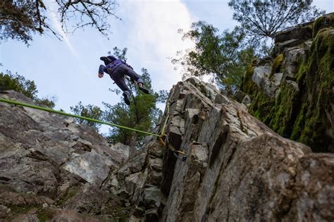 Escalador Cayendo Por El Borde Del Acantilado Mientras Escala Foto