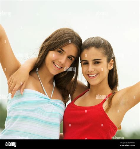 Portrait of two girls smiling with their hands raised Stock Photo - Alamy