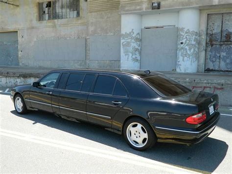 a black car parked in front of a building on the side of the road with ...