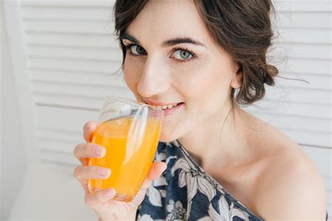 Muchacha Que Bebe El Zumo De Naranja En El Desayuno En Cama Foto De