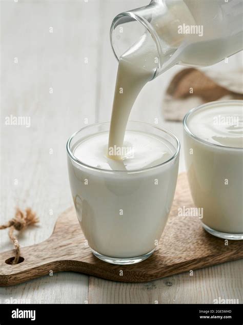 Pouring Kefir Buttermilk Or Yogurt With Probiotics Yogurt Flowing From Glass Bottle On White