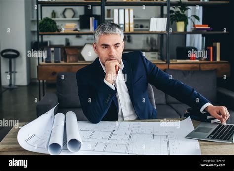 Mature Architect Working With Drawings In Office Stock Photo Alamy