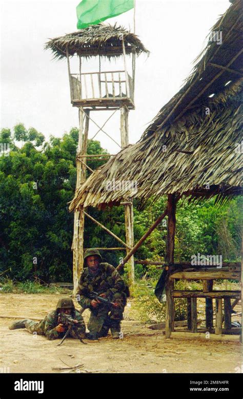 Marines Armed With M60s Advance Through A Village During A