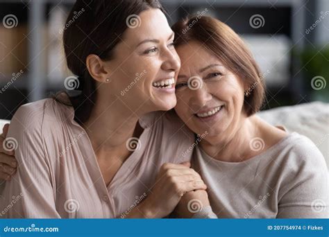 Close Up Smiling Mature Mother And Grownup Daughter Cuddling Stock