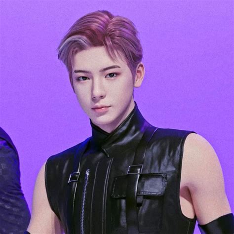 A Young Man Wearing A Leather Vest And Black Gloves Standing In Front Of A Purple Background