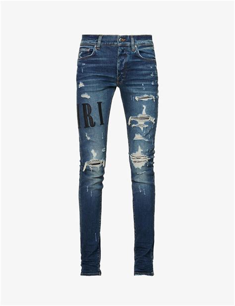 Amiri Leather Logo Appliqué Ripped Slim Fit Stretch Denim Jeans In Blue