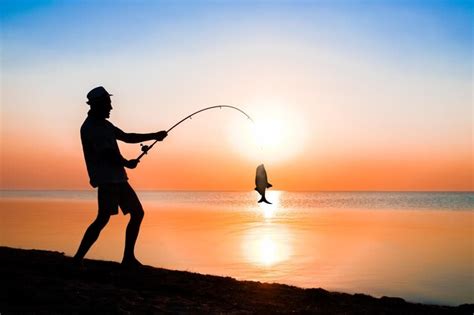 Um pescador feliz pescando peixes à beira mar em uma viagem de silhueta