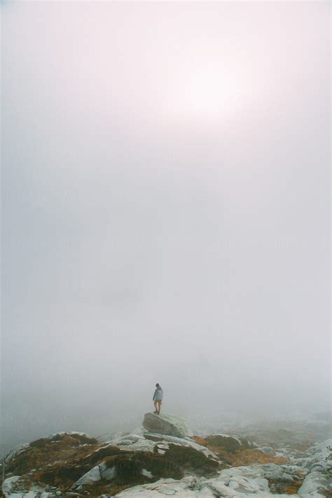 "Man Standing Alone On Granite Boulder In Thick Fog" by Stocksy Contributor "Luke Mattson" - Stocksy