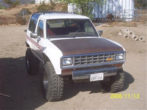 A White And Brown Pick Up Truck Parked In The Dirt