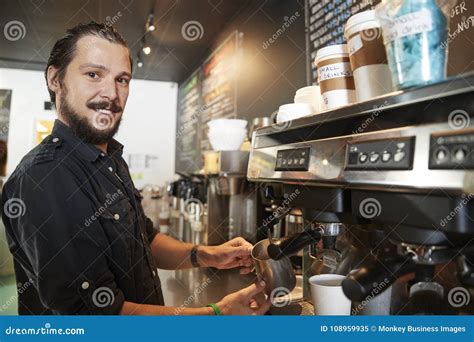 Portrait Of Male Barista Behind Counter In Coffee Shop Stock Image