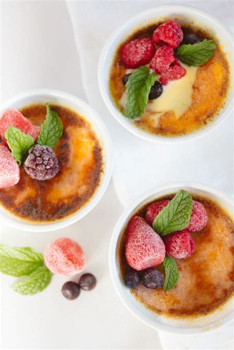 Three Small Bowls Filled With Pudding And Fruit On Top Of A Table Next