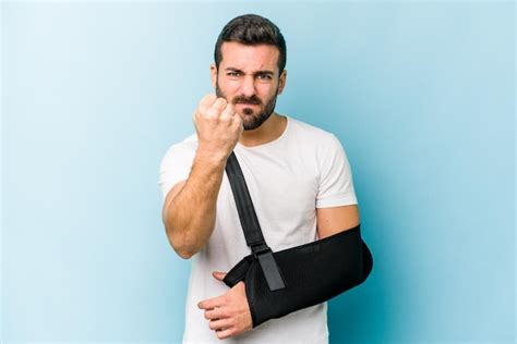 Premium Photo Young Caucasian Man With Broken Hand Isolated On Blue