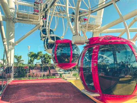 Ferris Wheel In The City Center Against The Blue Sky Red Cabins With