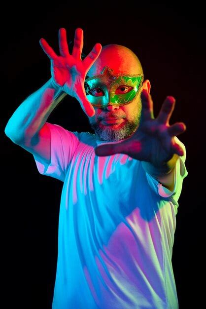 Retrato de homem careca usando máscara de carnaval fazendo gestos