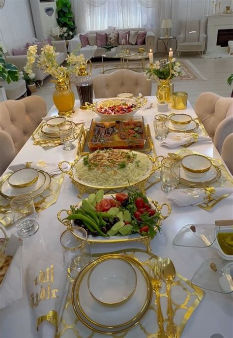 A Table Set With Plates Silverware And Gold Trimmings In A Formal