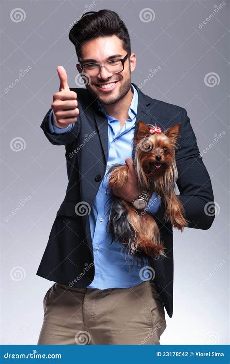 Casual Young Man Holds Puppy And Shows Thumb Up Stock Photo Image Of