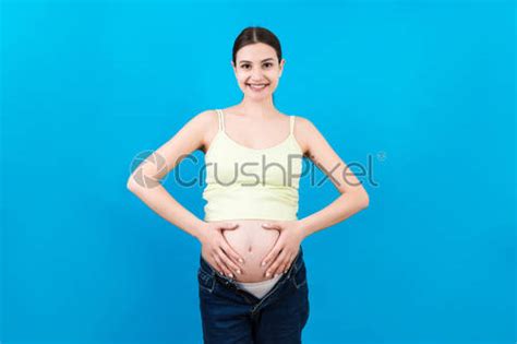 Pregnant Woman In Unzipped Jeans Showing Her Naked Abdomen At Stock