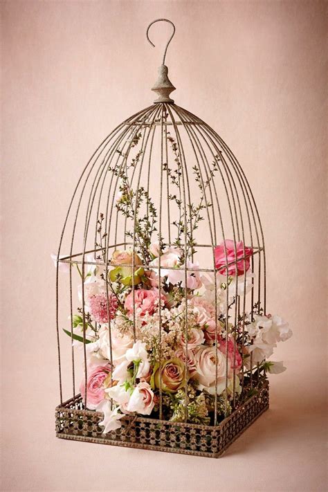 A Bird Cage With Flowers In It