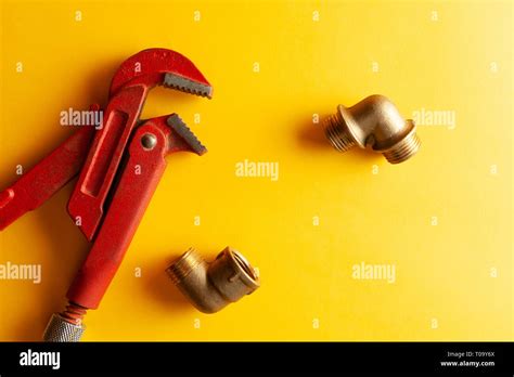 A Monkey Wrench On The Yellow Background With Some Fitting Connectors