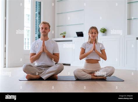 Peaceful Couple Sitting In Lotus Pose With Prayer Hands While