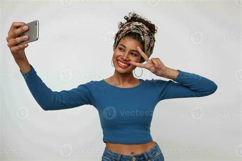 Cheerful Young Lovely Dark Haired Curly Lady With Nose Piercing Smiling