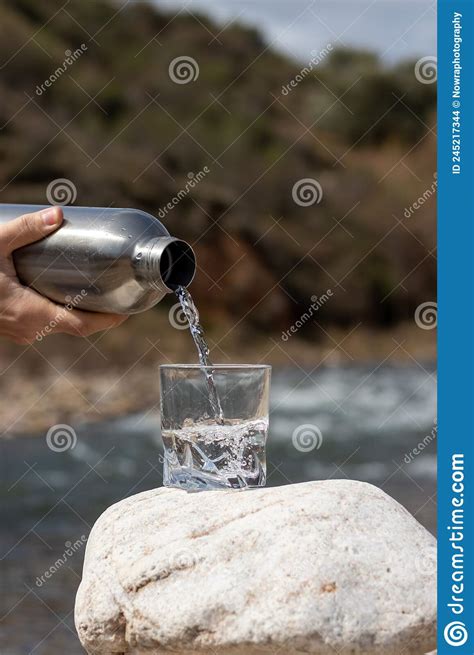 Close Up Pouring Purified Fresh Water From The Bottle On Glass Cup In