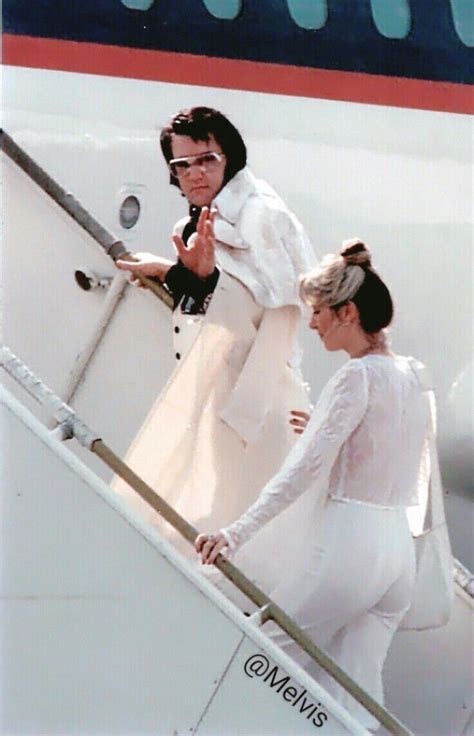 Two Women In White Outfits Walking Up The Stairs To An Airplane With