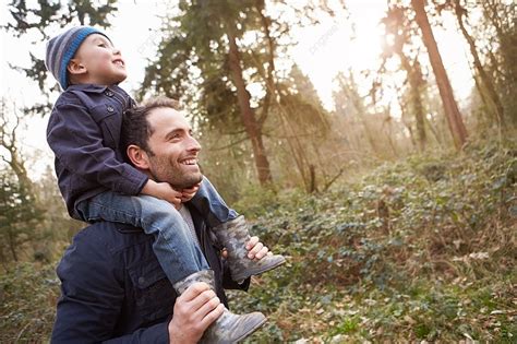 Father Carrying Son On Shoulders During Countryside Walk Background