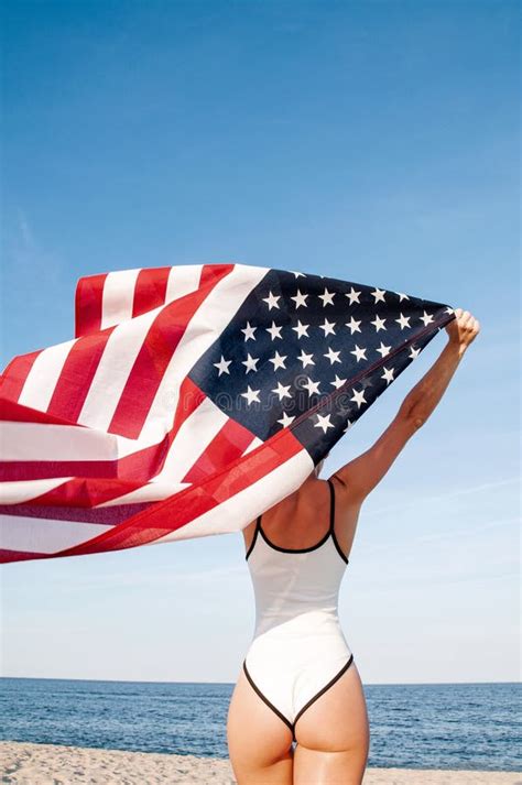 Beautiful Patriotic Woman Holding An American Flag On The Beach Usa