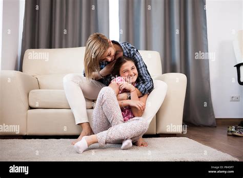 Mother Is Cuddling Her Teenage Daughter And They Both Laugh Stock Photo