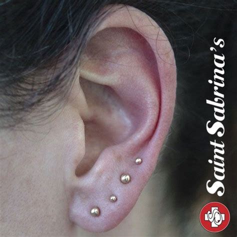 Four Earlobe Piercings With Yellow Gold Ball Ends Done By Courtney Jane