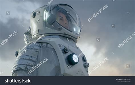 Shot Of Female Astronaut In The Space Suit Looking Around Frozen Alien