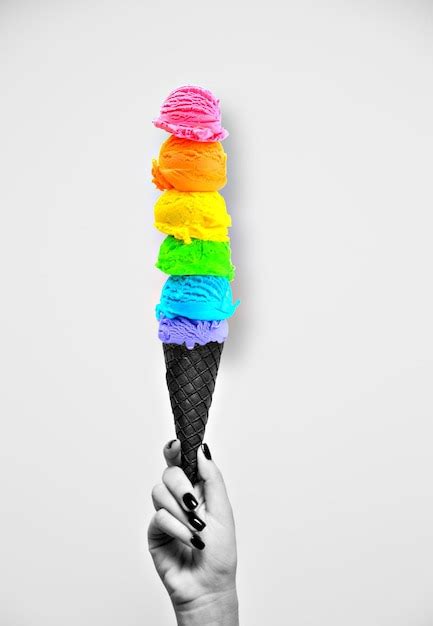 Una Mano Sosteniendo Un Cono De Helado De Arco Iris Foto Premium