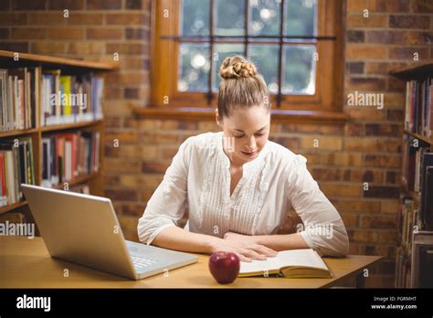 Blonde Teacher Reading Book In The Library Stock Photo Alamy