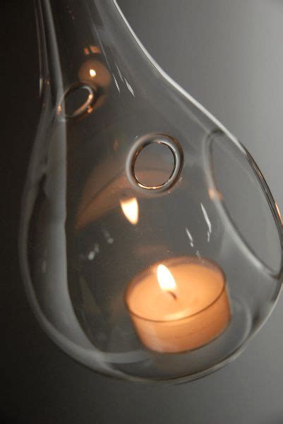 The Water Drop Glass Hanging Candle Holder Has Two Lit Candles In It