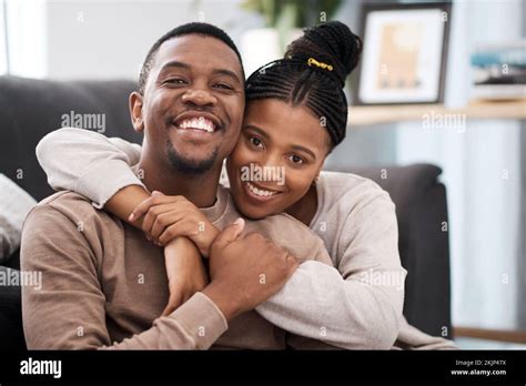 Love Hug And Portrait Of A Happy Couple On Sofa In The Living Room Of