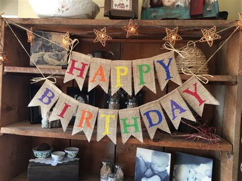 a happy birthday banner hanging on a shelf in a room with pictures and ...