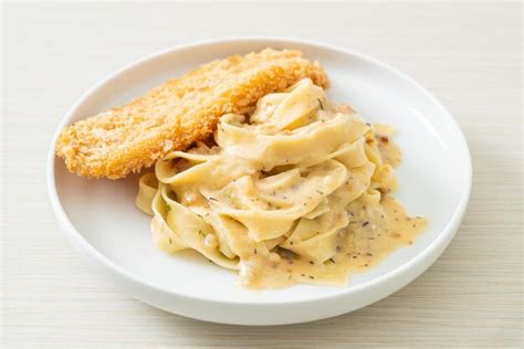 Premium Photo | Fettuccine pasta white cream sauce with fried fish